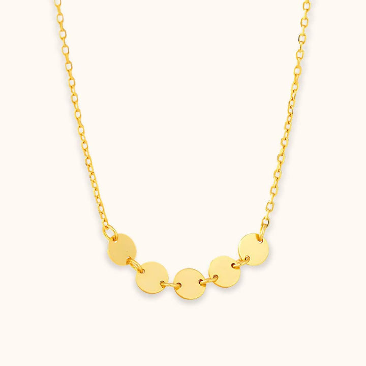 Gold mini disc necklace with adjustable chain, highlighting its versatile and lightweight design for effortless styling.