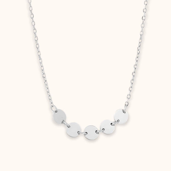 Silver mini disc necklace showcasing its modern and polished design, great for layering or wearing solo for a timeless look.