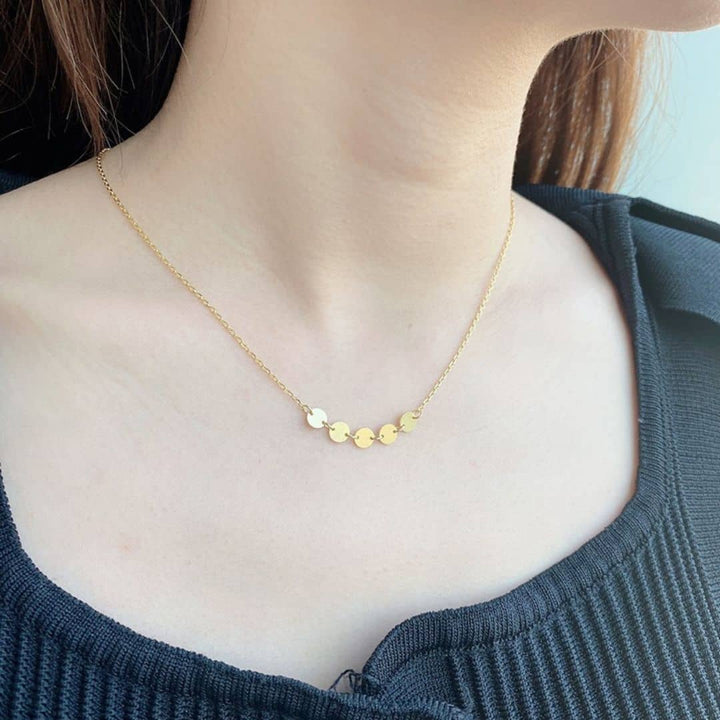 Minimalist gold mini disc necklace elegantly styled, perfect for layering and everyday wear. Ideal for sensitive skin and gifting.